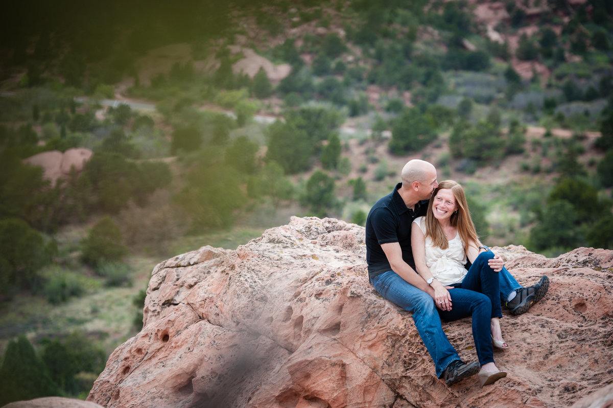 engaged couple sitting on red rocks