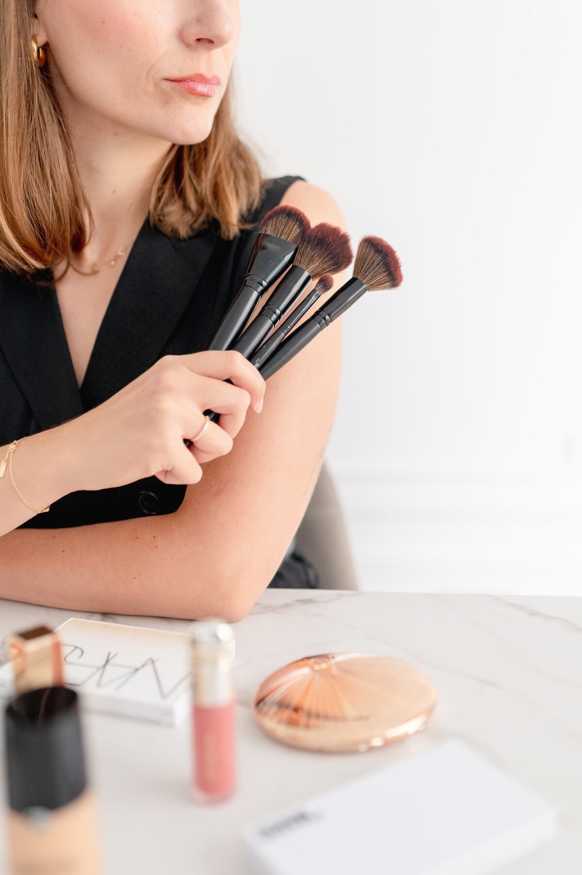 Femme qui tient des pinceaux de maquillage