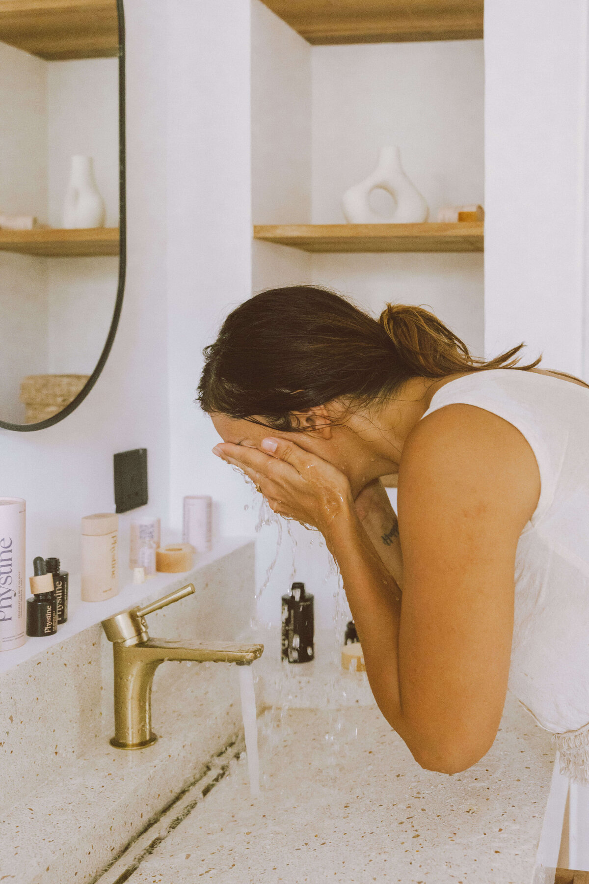 Skin care brand photography of woman cleansing face during morning skincare routine