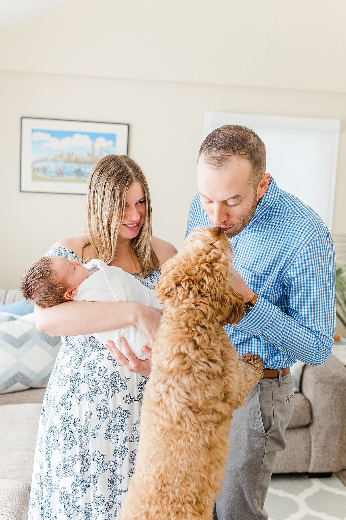 man kisses dog during in home newborn photo session with Sara Sniderman Photography  in Natick Massachusetts