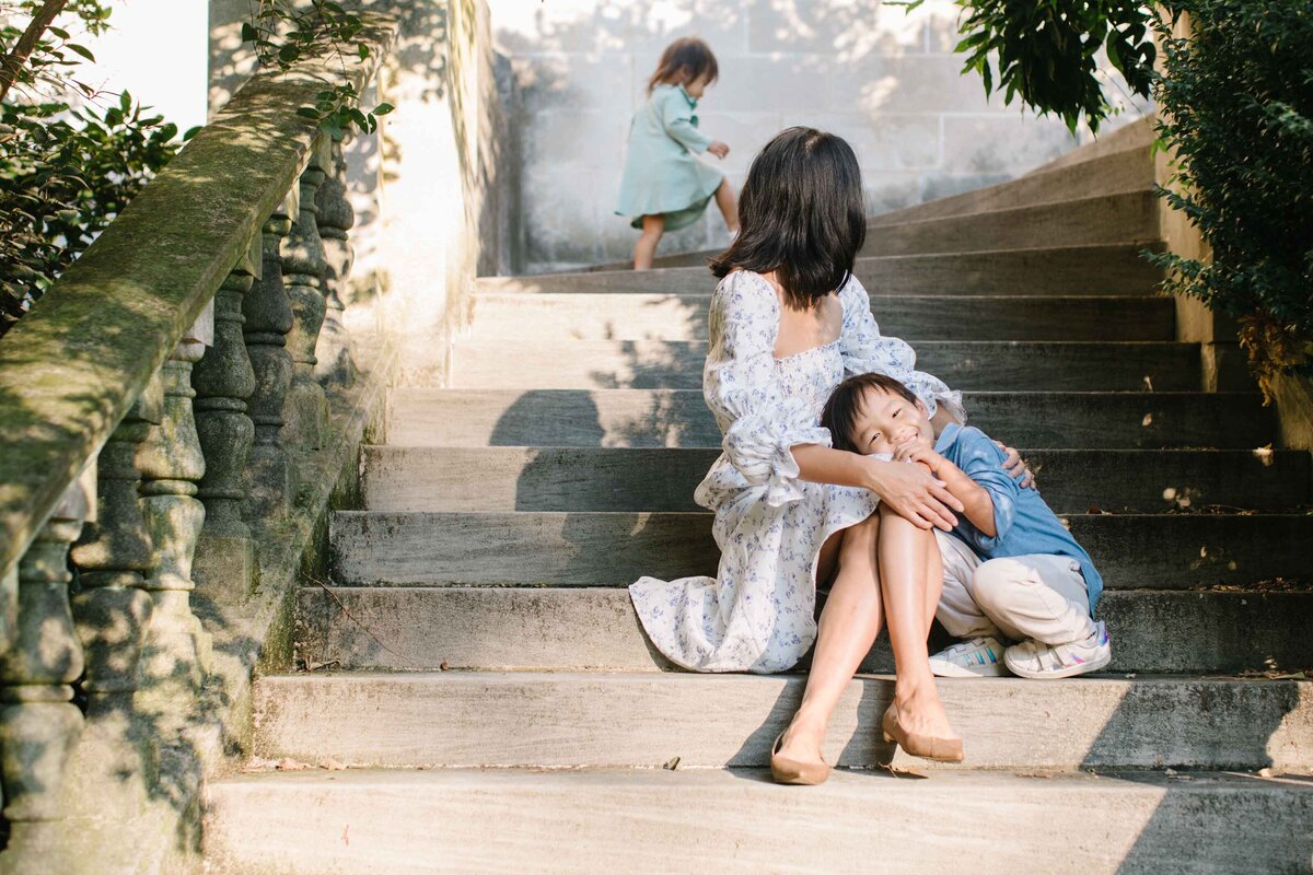 mother with two young children on garden staircase