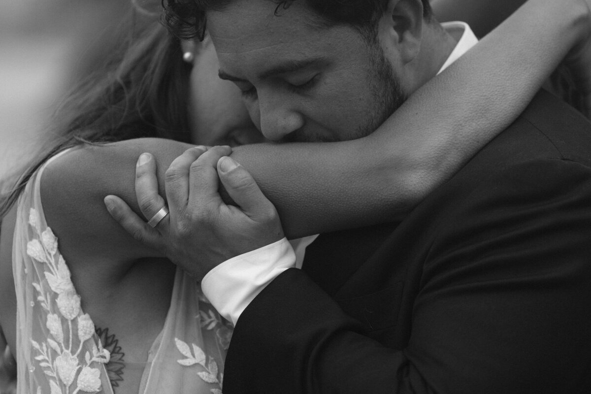 groom intimately kisses brides arm that has goosebumps all over it 