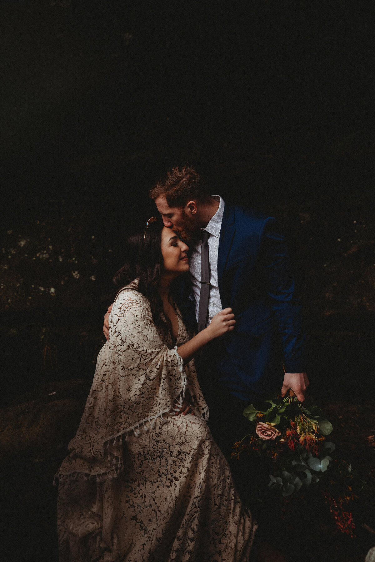 Boho bride and groom share an intimate hug at Hocking Hills Cabin cave after eloping.