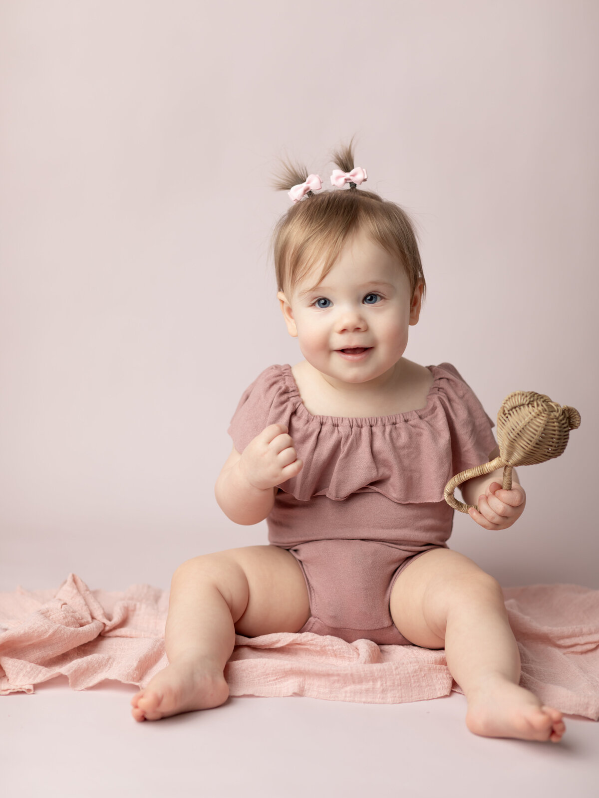 one year old girl in pink for first birthday photoshoot