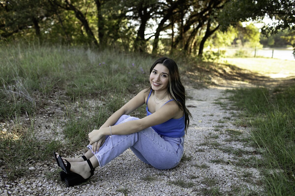 A high school senior stands confidently, with a relaxed but poised expression