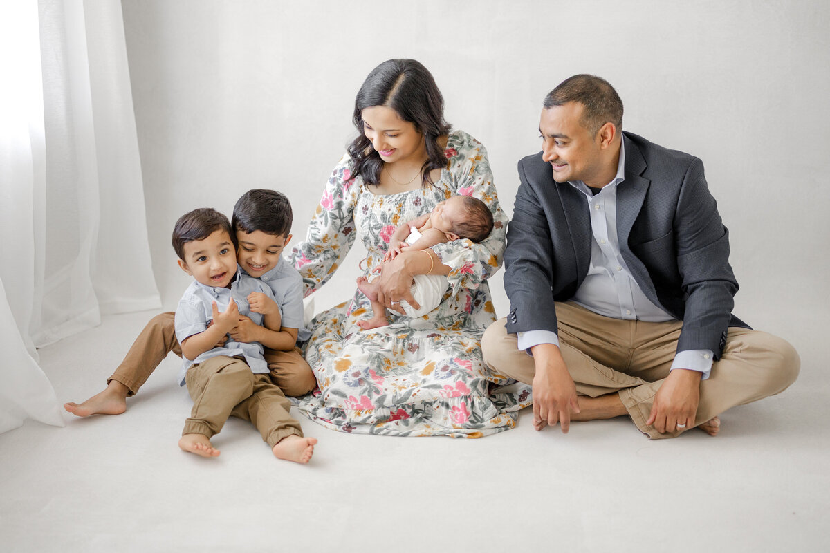 Elegant newborn family portrait in Tampa studio with mother holding baby boy in soft natural light