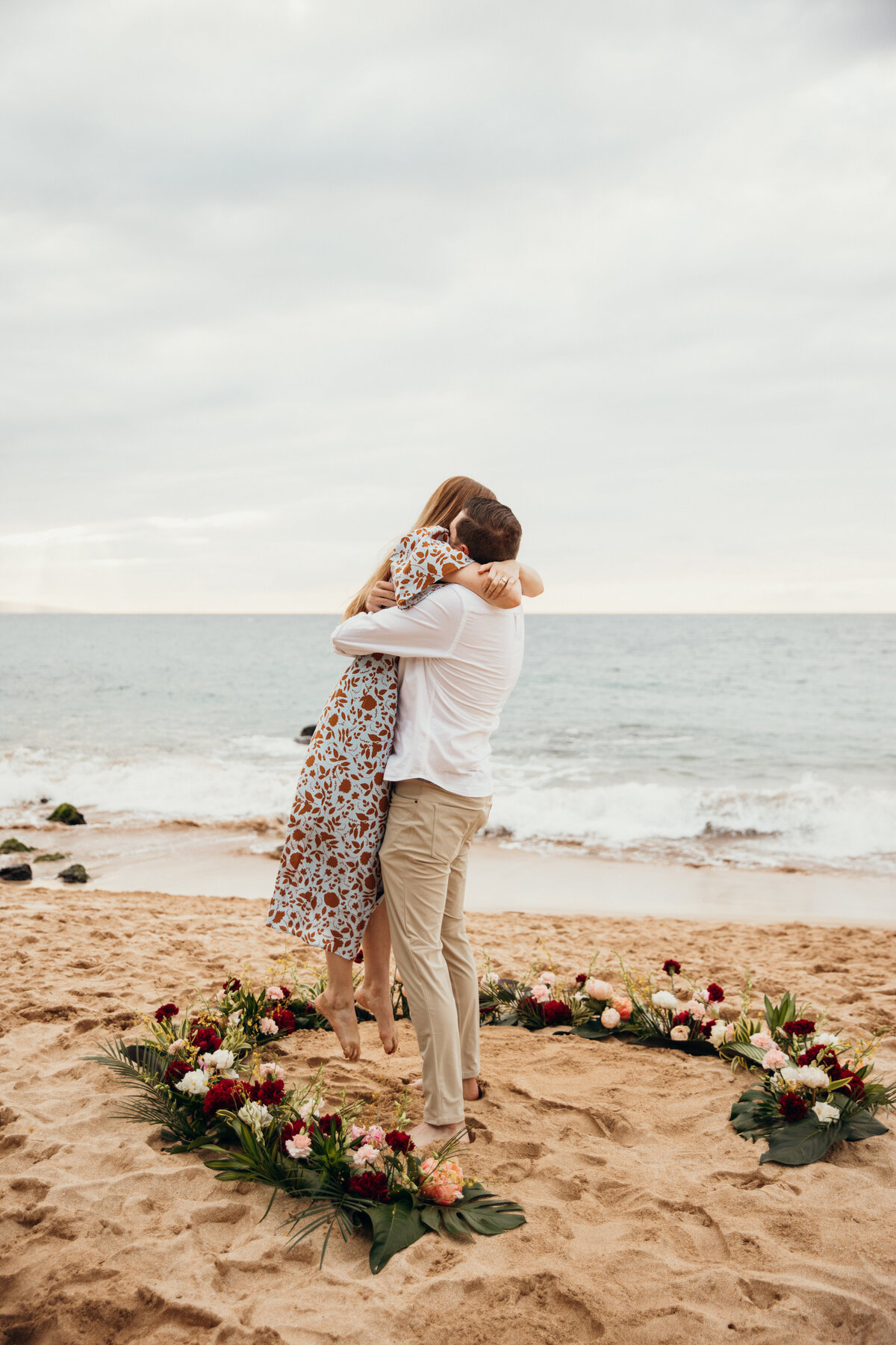 Hawaii Engagement Photographer captures man lifting woman to celebrate proposal