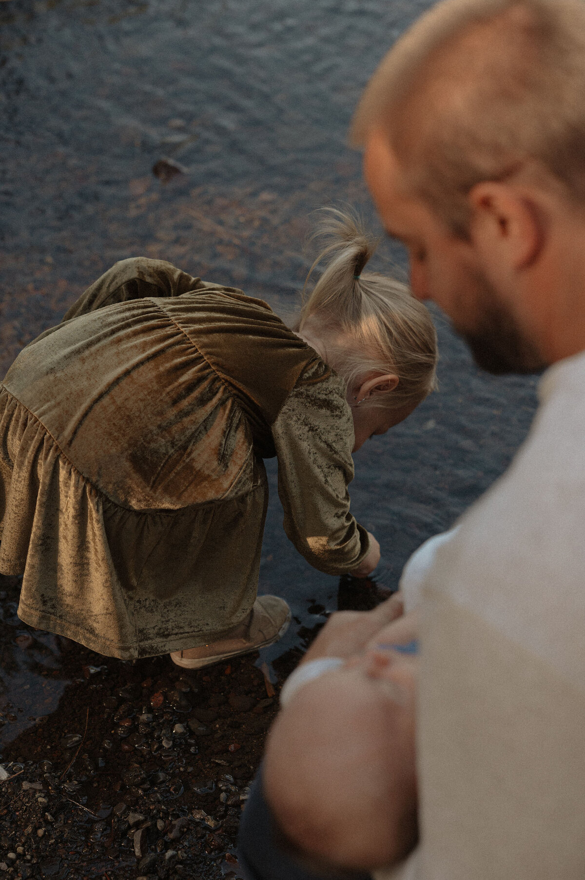 father and daughter exploring the river and looking at rocks in Bend, Oregon