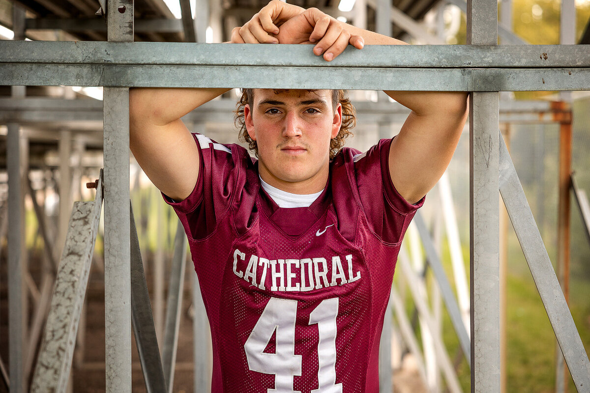 Senior football player posed under the bleachers.