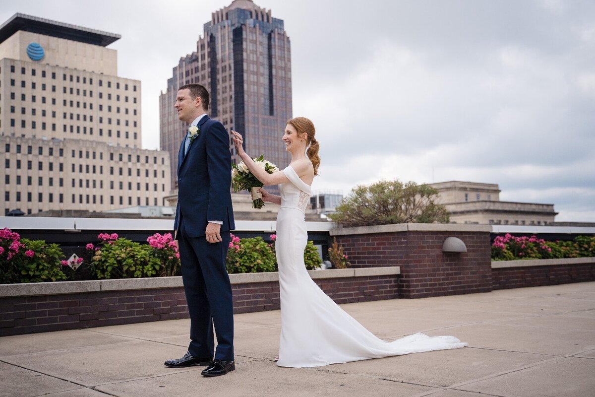 jps-events-first-look-bride-tapping-groom-shoulder-rooftop-downtown-indianapolis.jpg