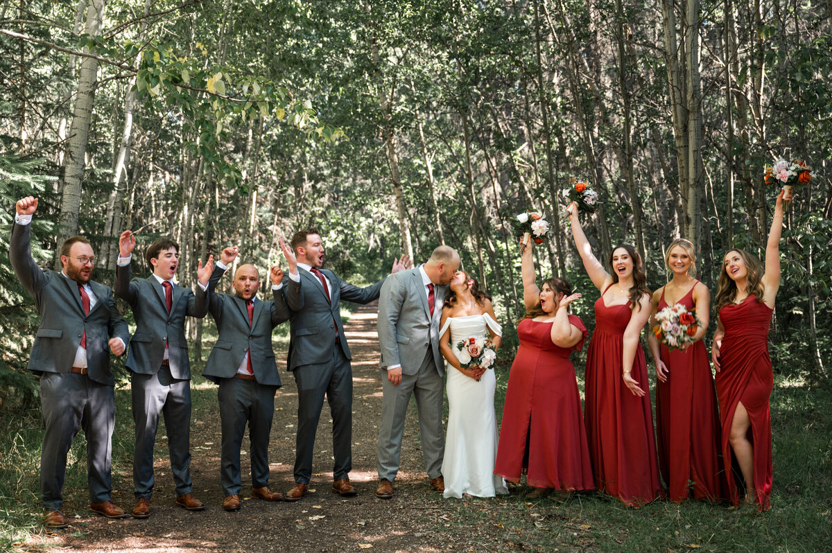 wedding party celebrate during portraits in the forest
