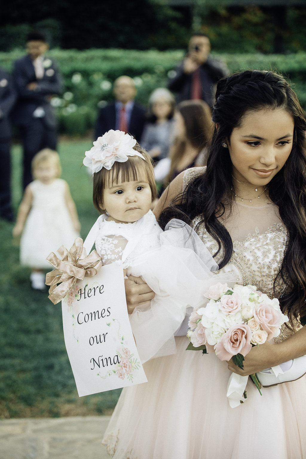 Wedding Photograph Of Woman Carrying a Toddler and a Bouquet While Walking Los Angeles