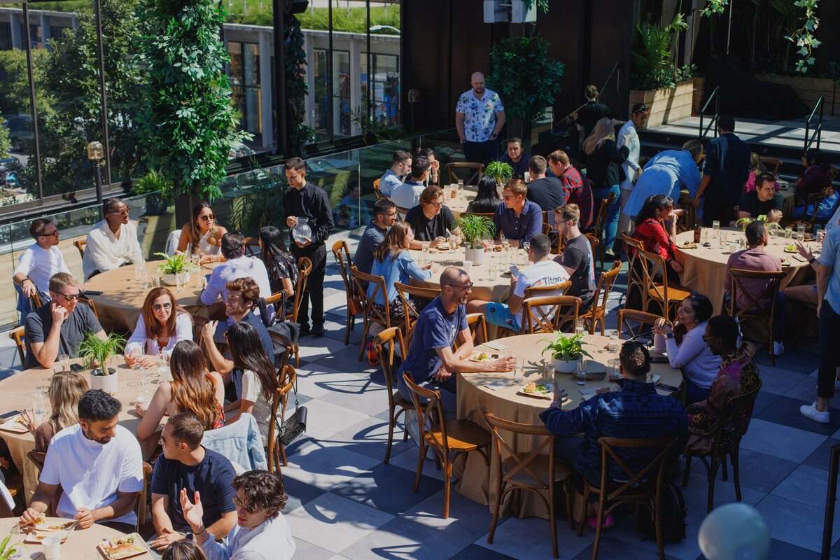 Guests seated at round tables on the Norwood rooftop during Titan Day 3 in New York, enjoying food, conversation, and branded hospitality.