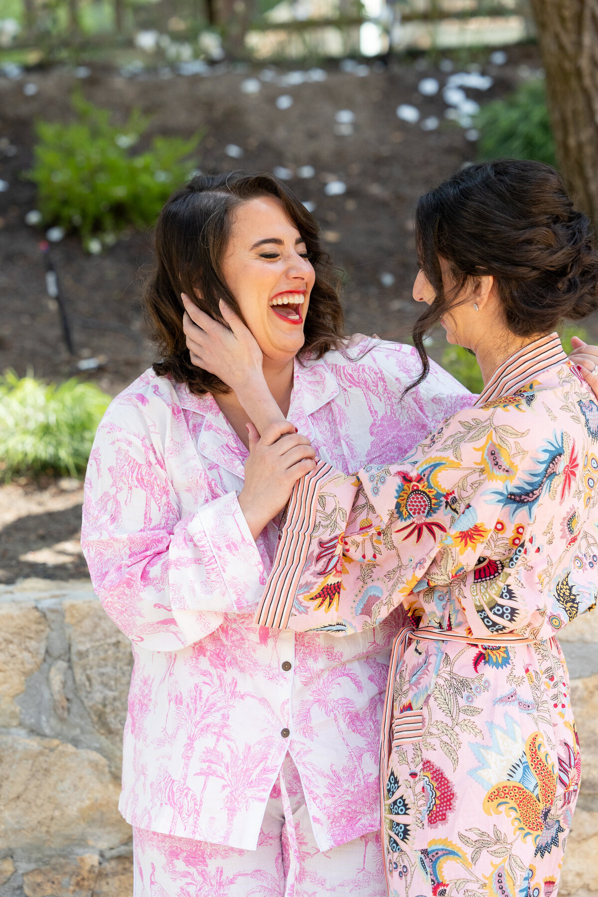 Two women laughing with their arms around each other