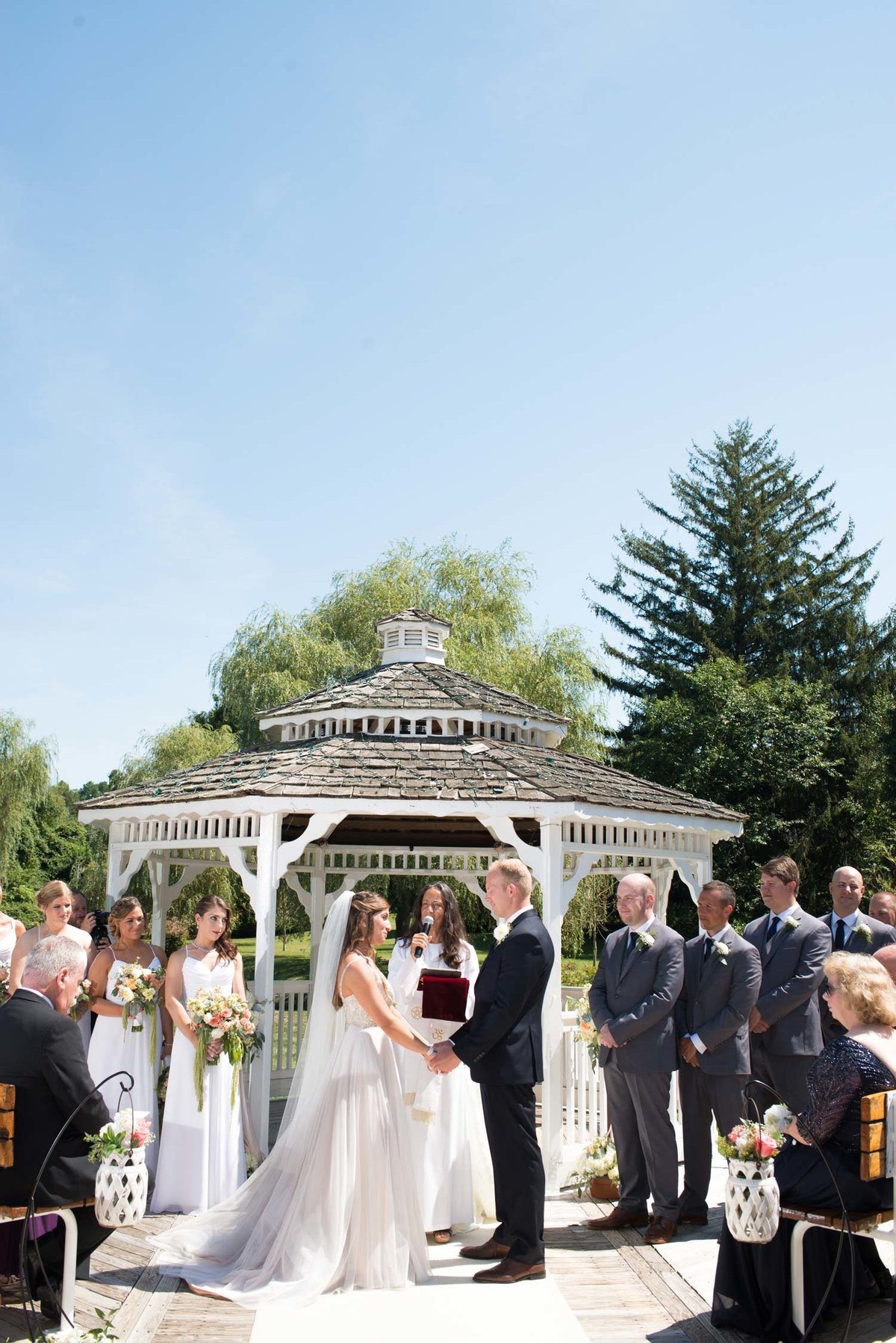 Bride and groom looking at one another holding hands at the alter at Flowerfield