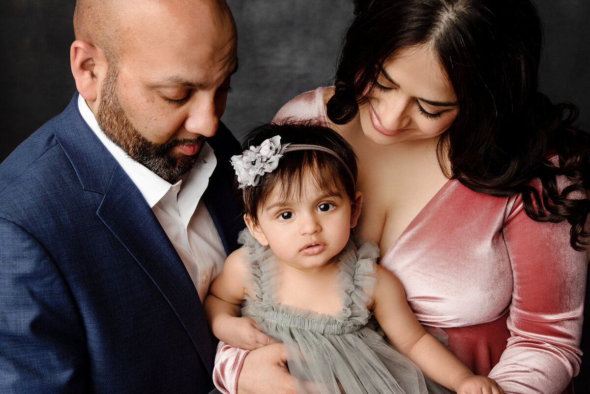 st-louis-family-photographer-baby-girl-wearing-gray-tulle-dress-with-mom-and-dad-looking-down