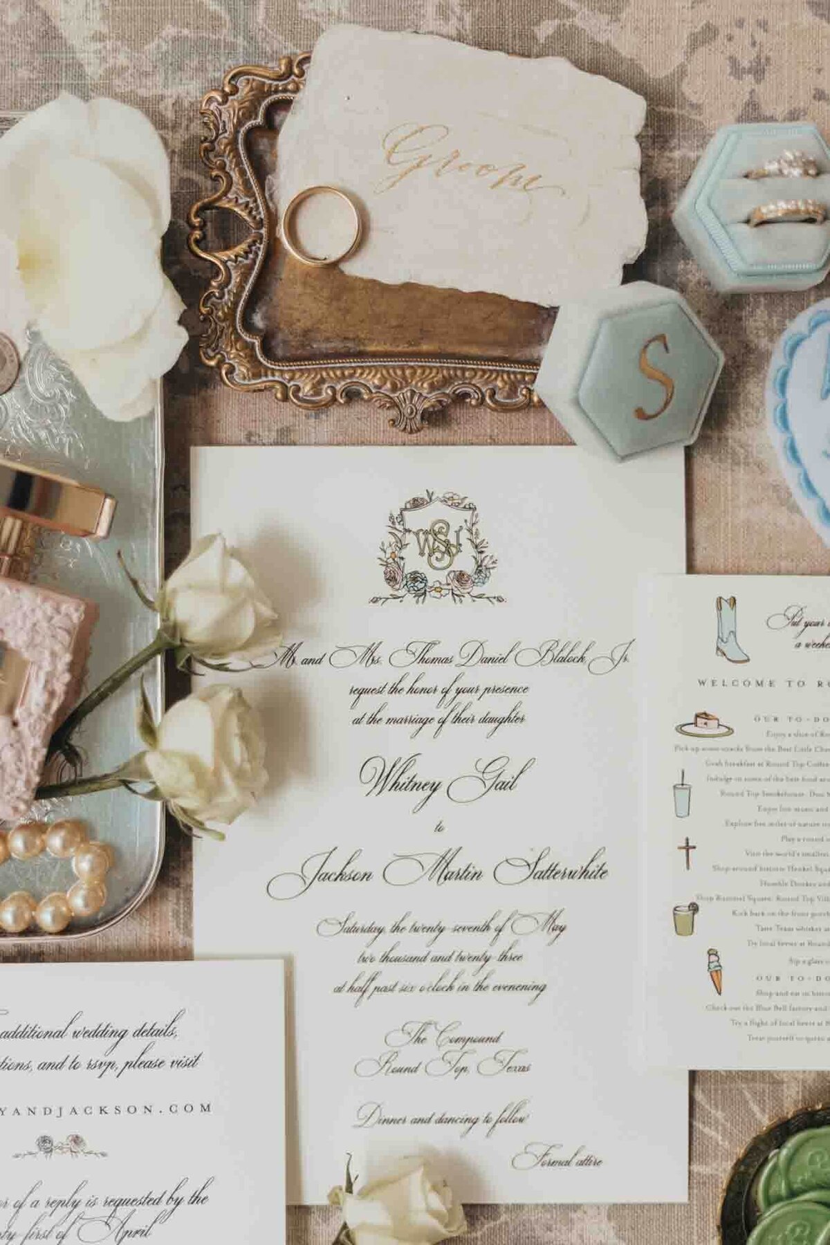 flat lay of invitation details with rings.