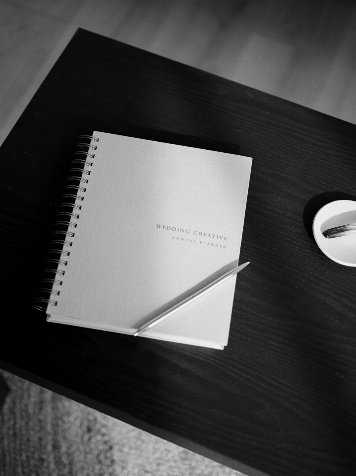 black coffee table with linen planner, palo santo with dish by Michigan film branding photographer Christina Harrison