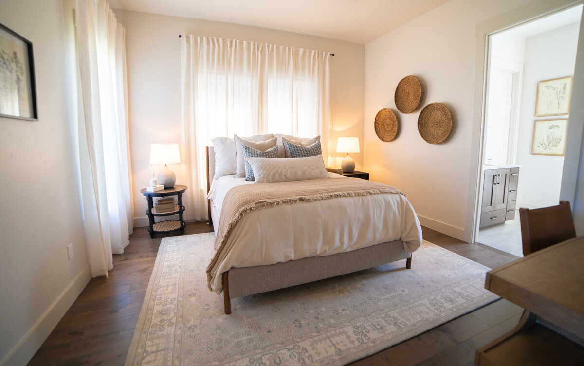 luxury bedroom with white dresser white sitting chiar and bed with blue blanket