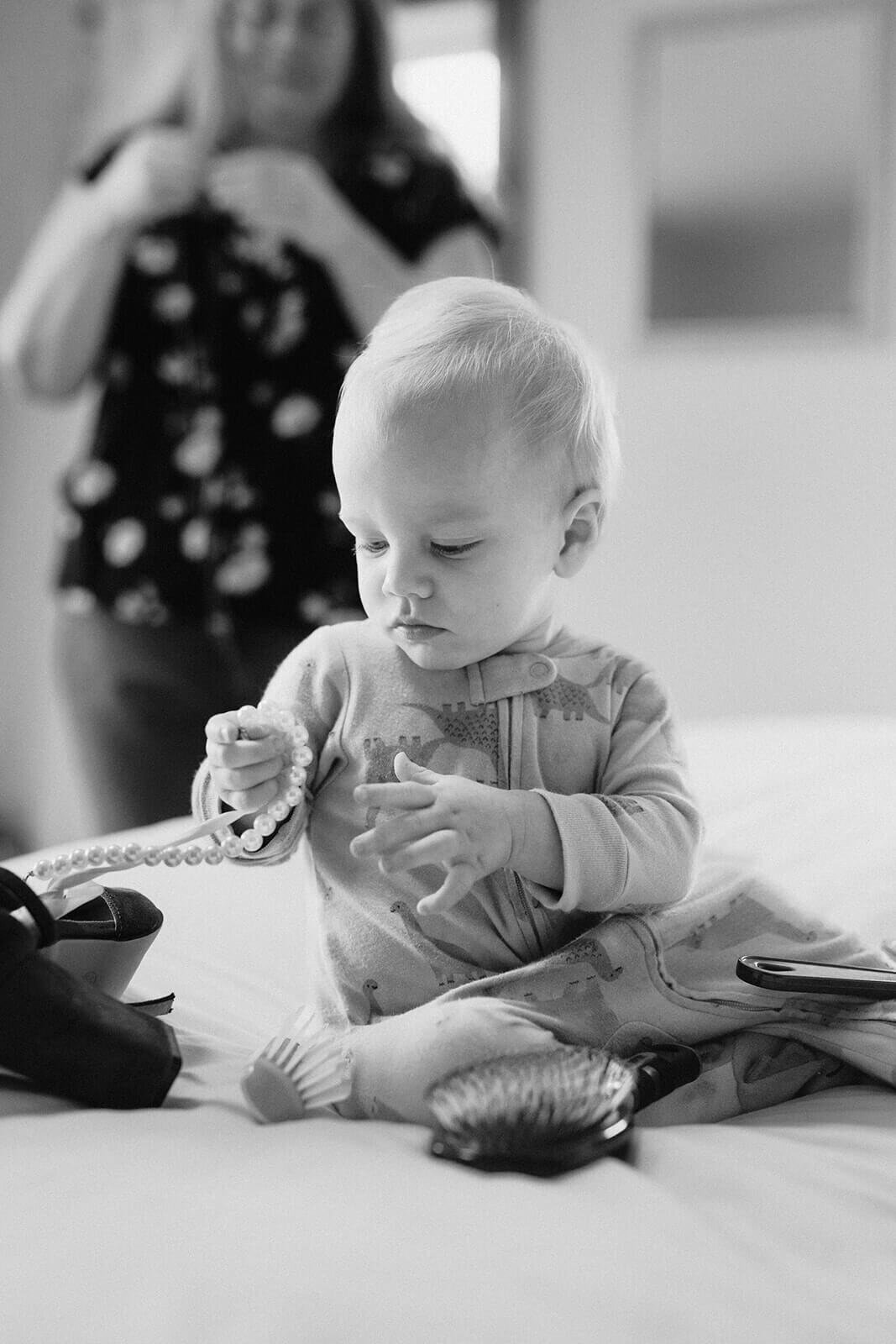 baby playing with a pearl necklace