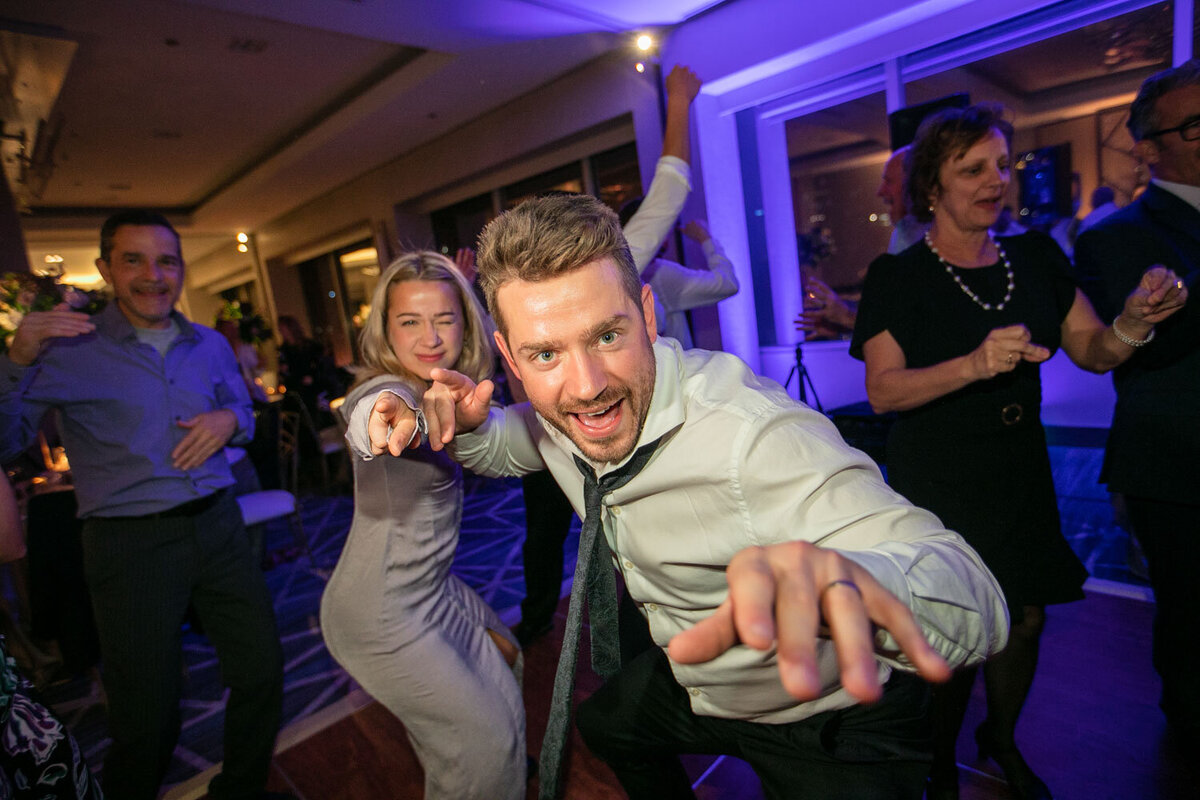 A man and a woman are dancing and pointing at the camera