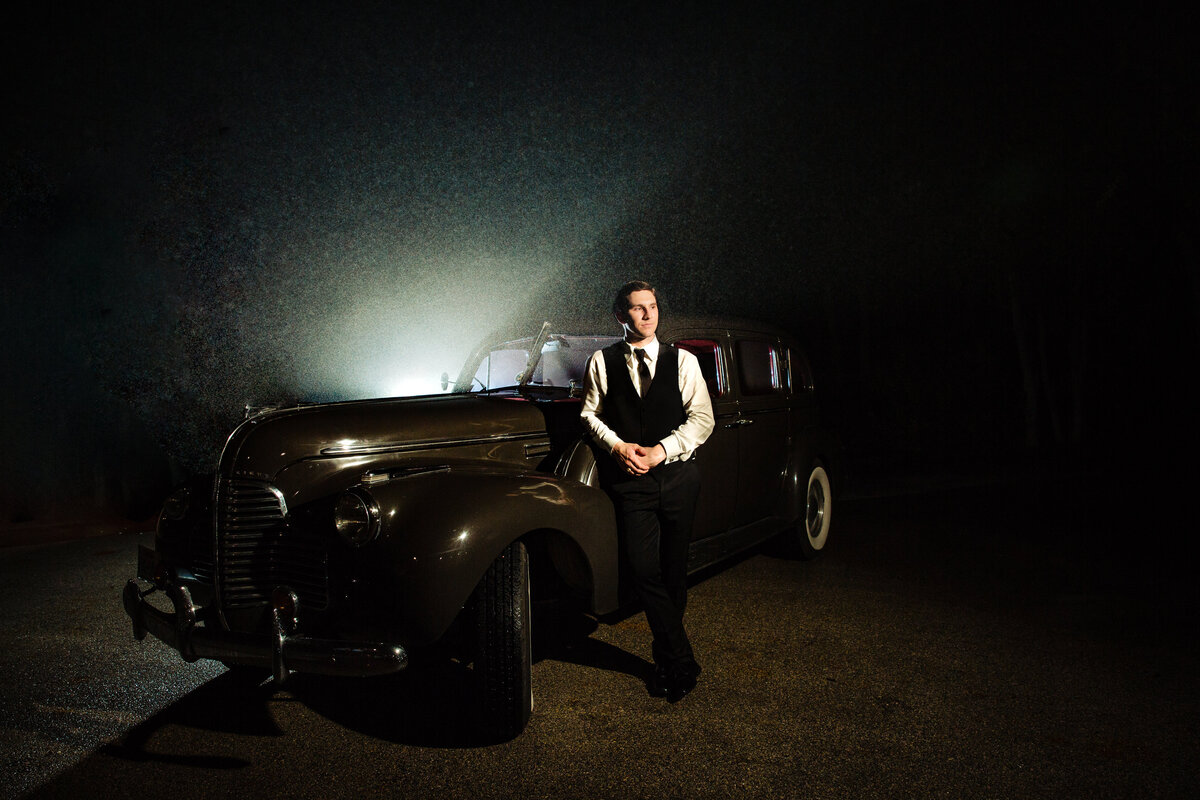 Groom poses with vintage car at The Milltown Historic District