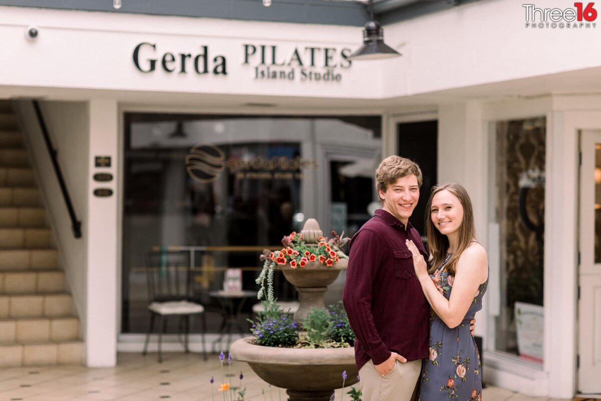 Engaged couple pose for a photo in Downtown Balboa Island