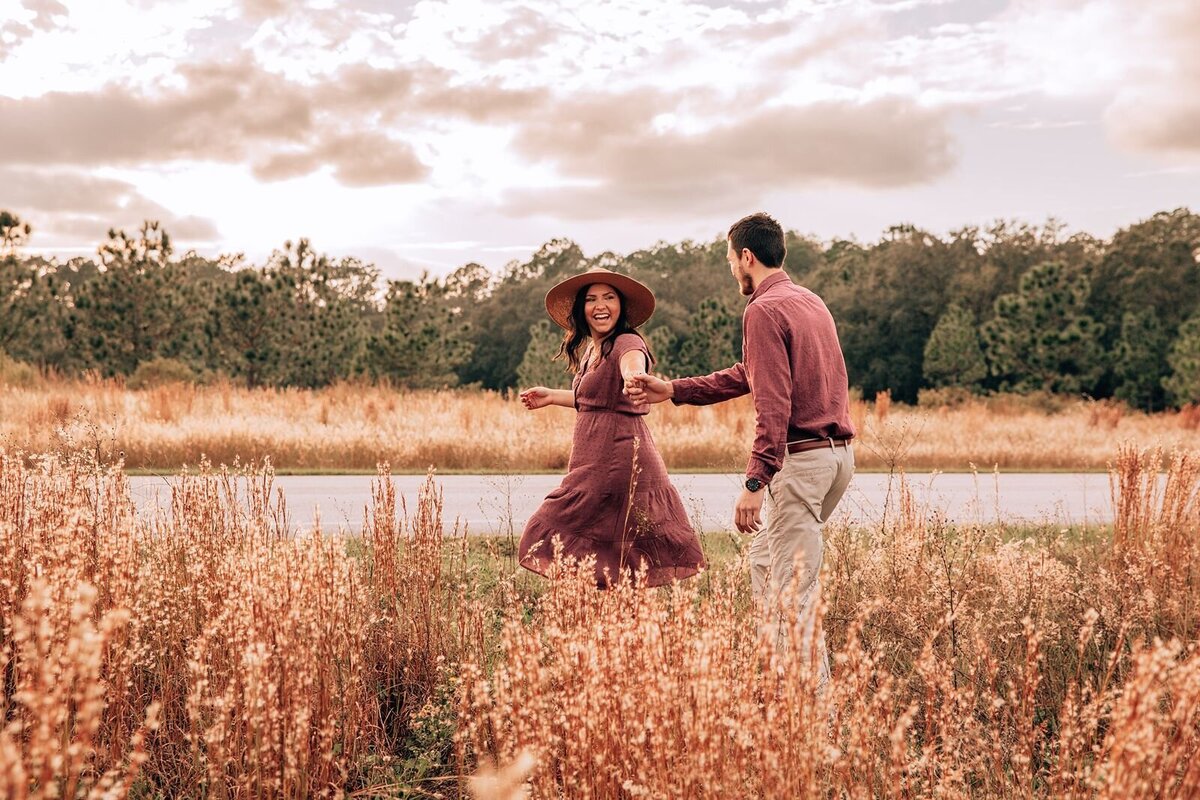 couple walking through tall grass field in lake louisa state park