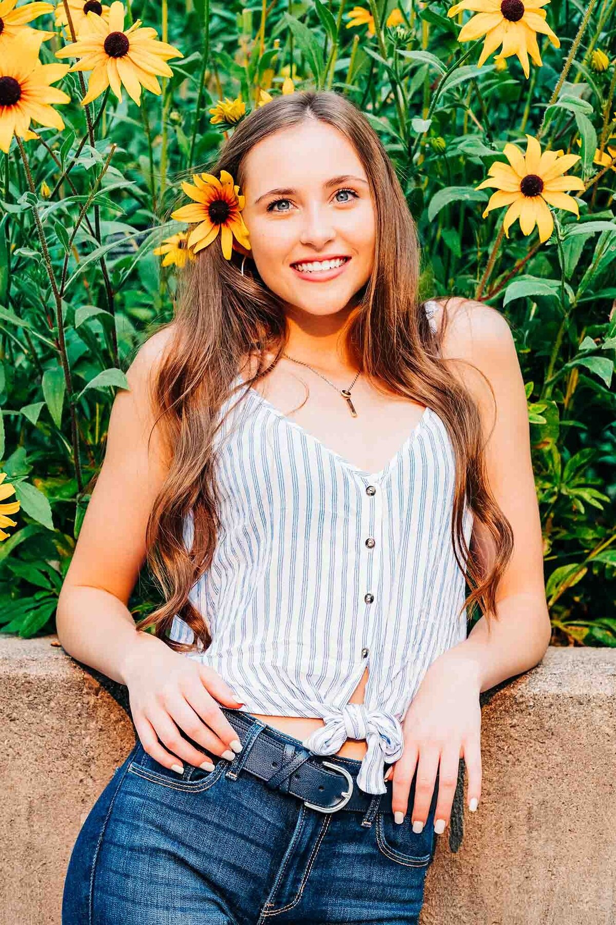 Senior photo of girl with flower in hair at University of Montana campus