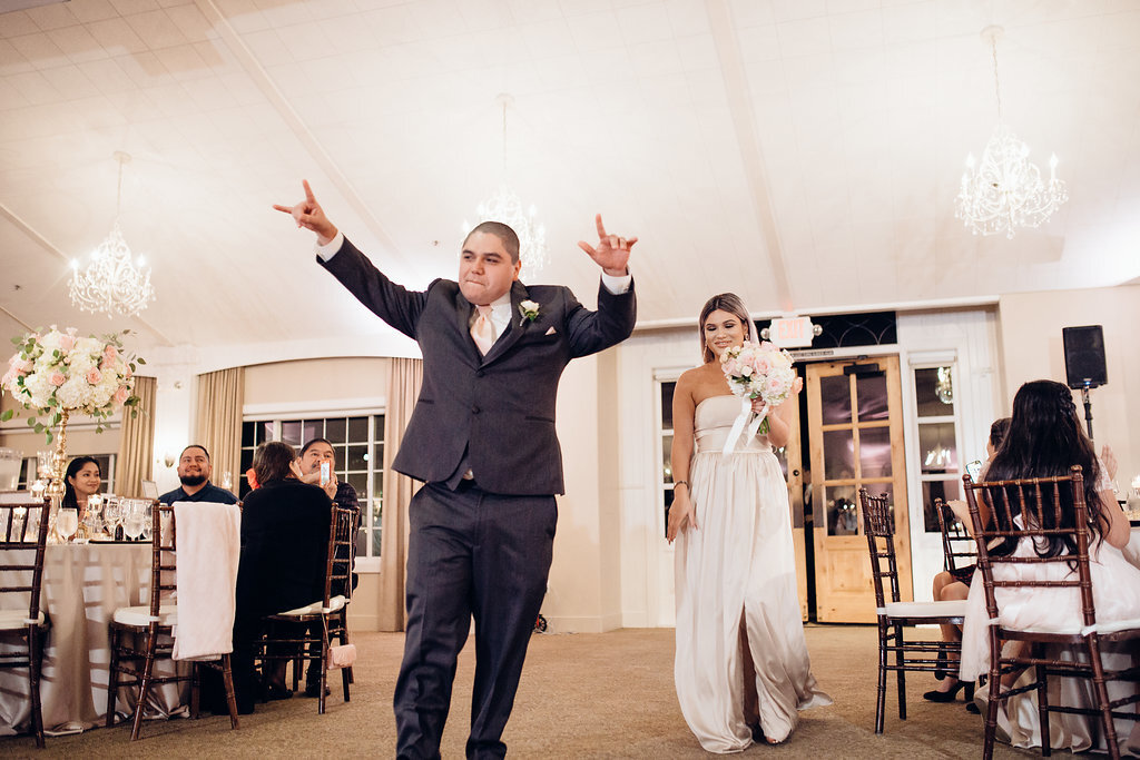 Wedding Photograph Of Groomsman Raising His Hands And Bridesmaid Carrying a Bouquet Los Angeles