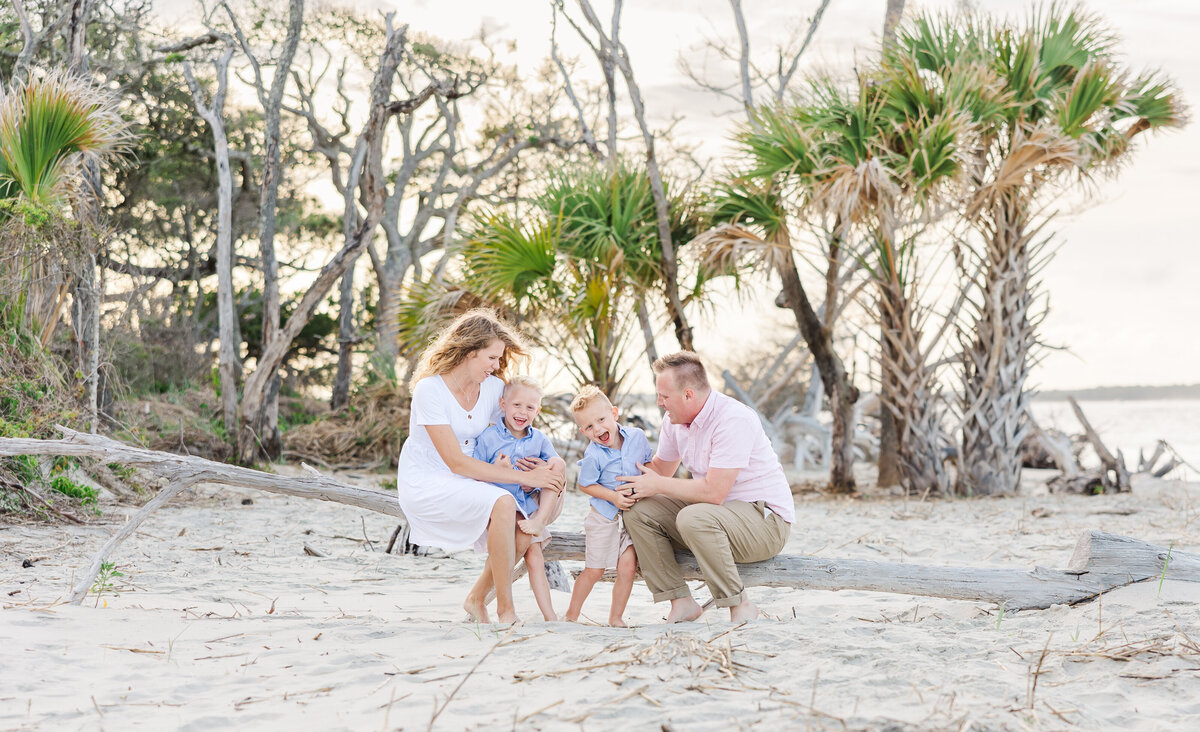mom and dad playing with little boys at the beach