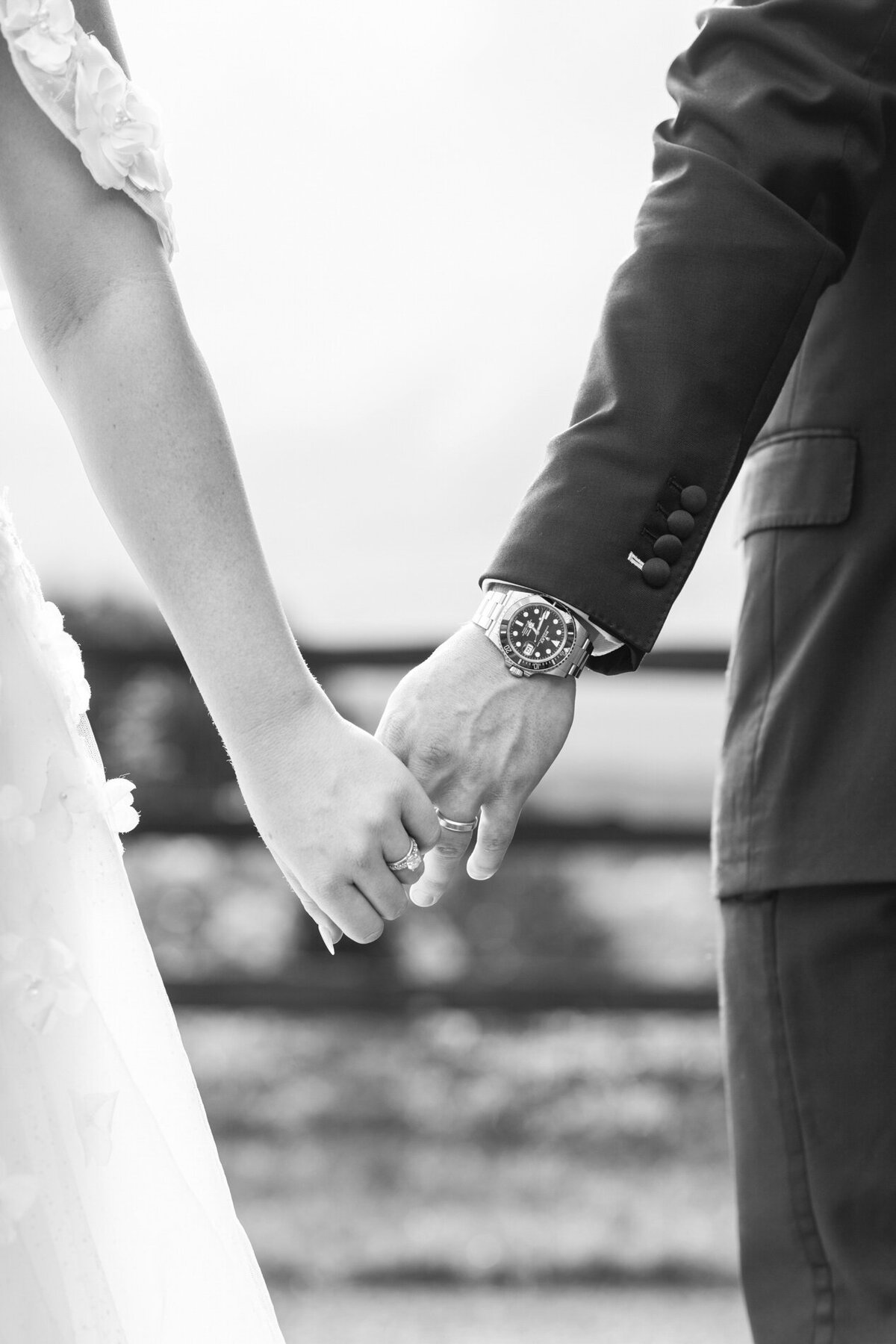 Couple holding hands and showing wedding rings