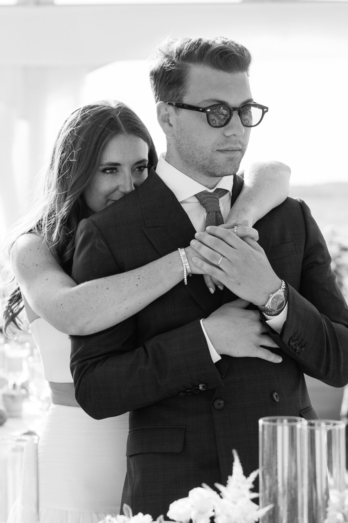 Iconic bride embracing her groom in black and white at their wedding reception