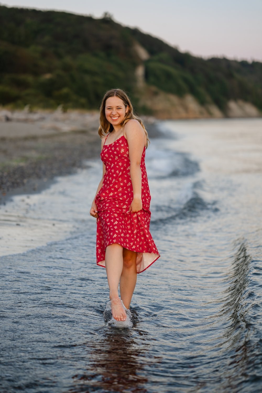 discovery park senior splashing in puget sound in red dress