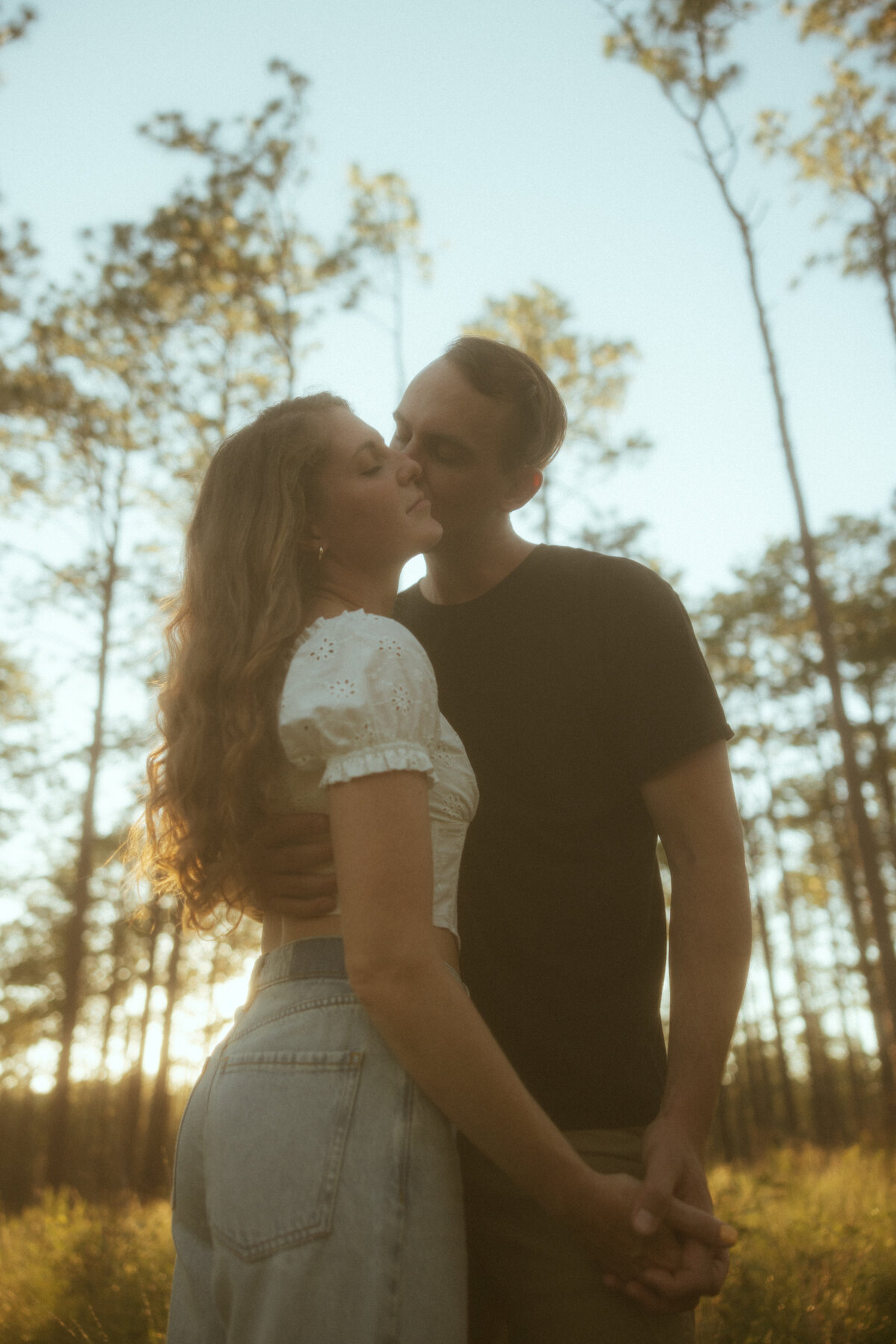Couple posing for portraits in a forest.