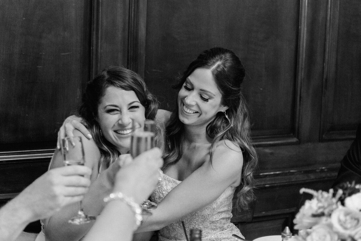 A candid moment between sisters at a wedding reception
