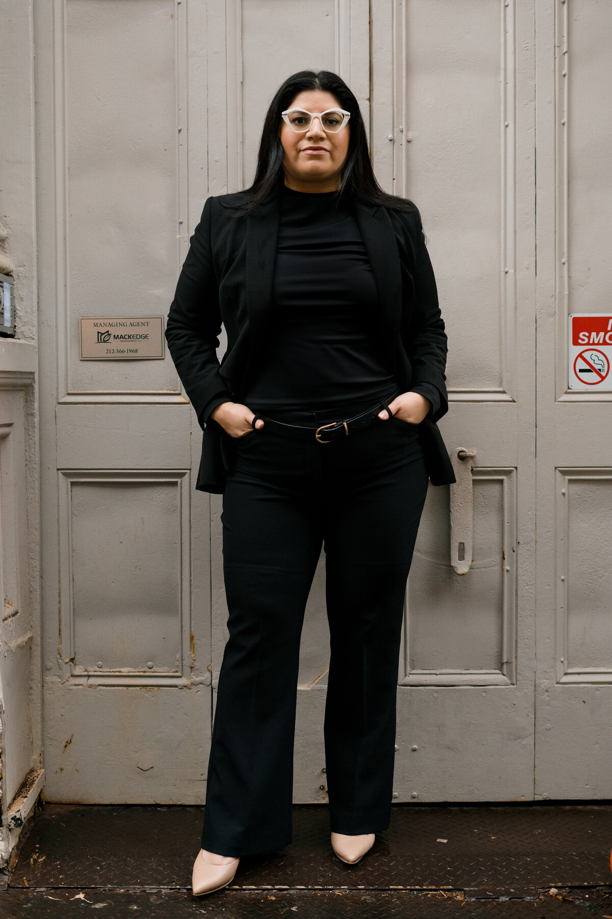 woman in a power stance with white glasses