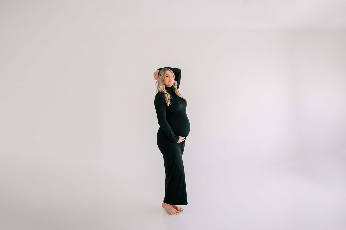 pregnant mom holding baby bump closing eyes captured by Branson MO maternity photographer Jessica Kennedy of The XO Photography