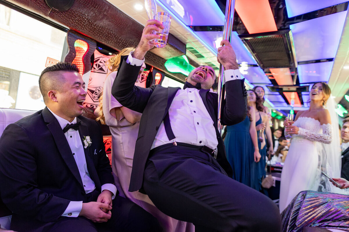 A man in a tuxedo is holding a glass in his hand