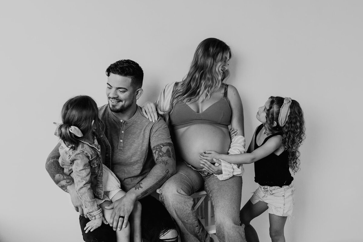 Black and white maternity image of a happy family