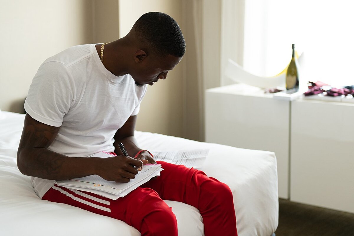 Groom sits on the bed and writes a letter to his Bride on the day of their wedding at Hyatt Regency Pittsburgh Airport