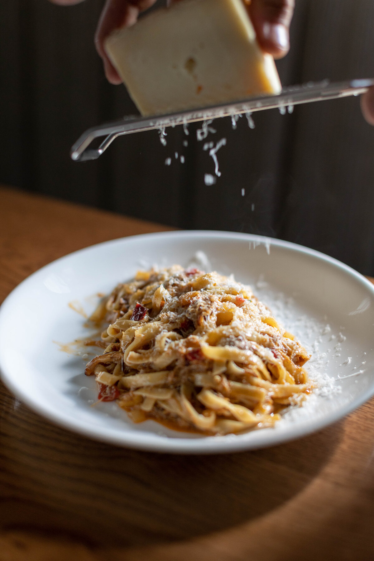 Grated cheese falling onto fresh pasta