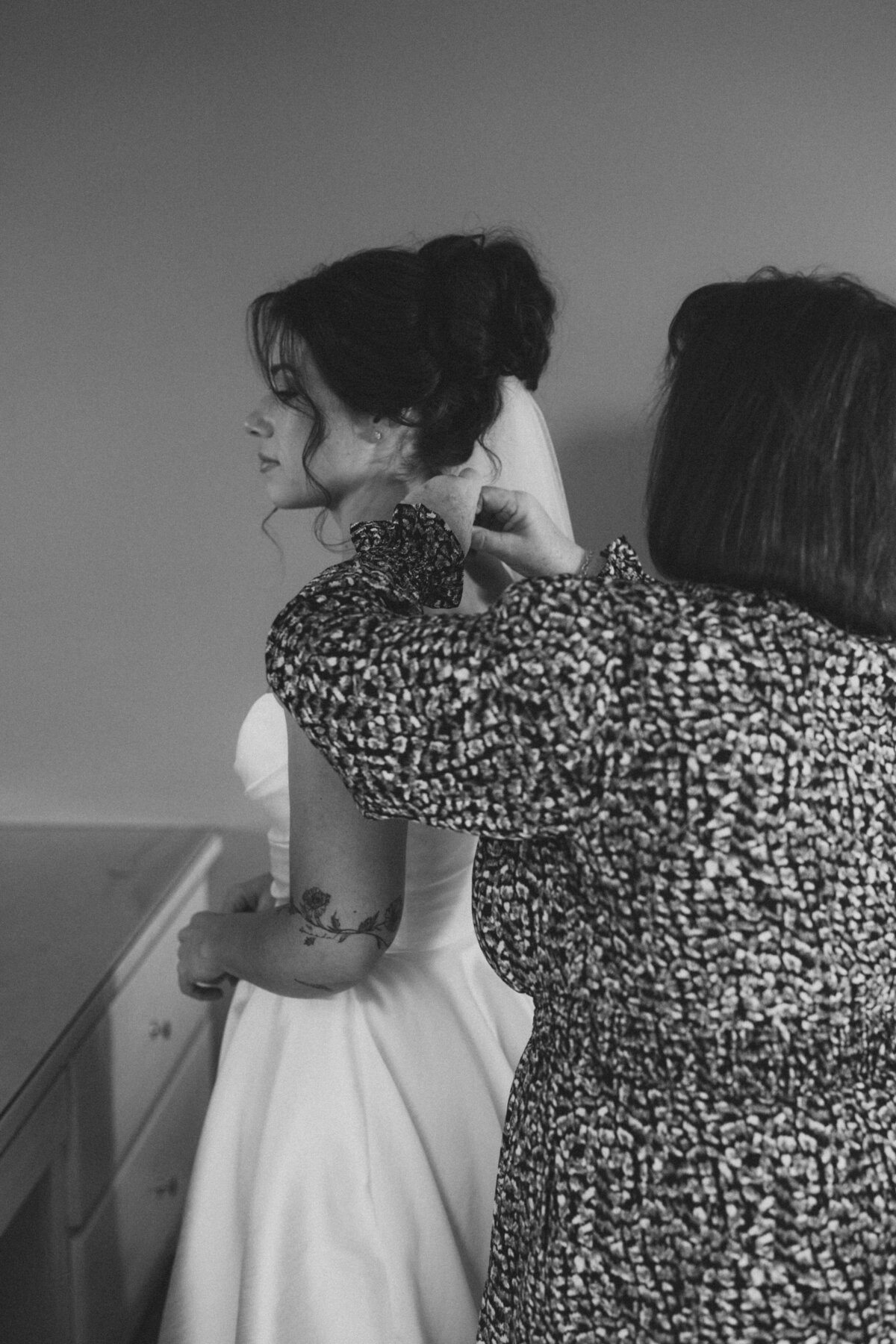 Brides mom putting on a necklace on the bride