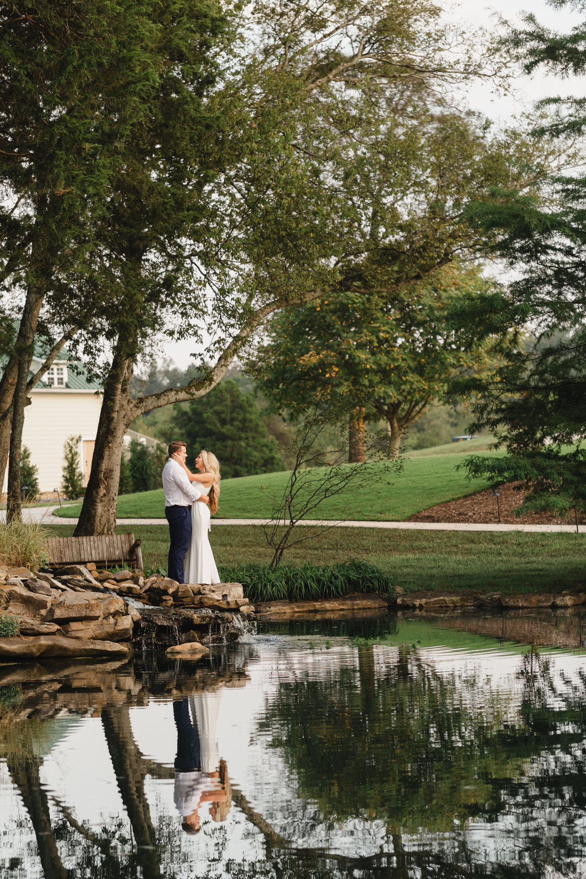 couple by pond at wedding venue