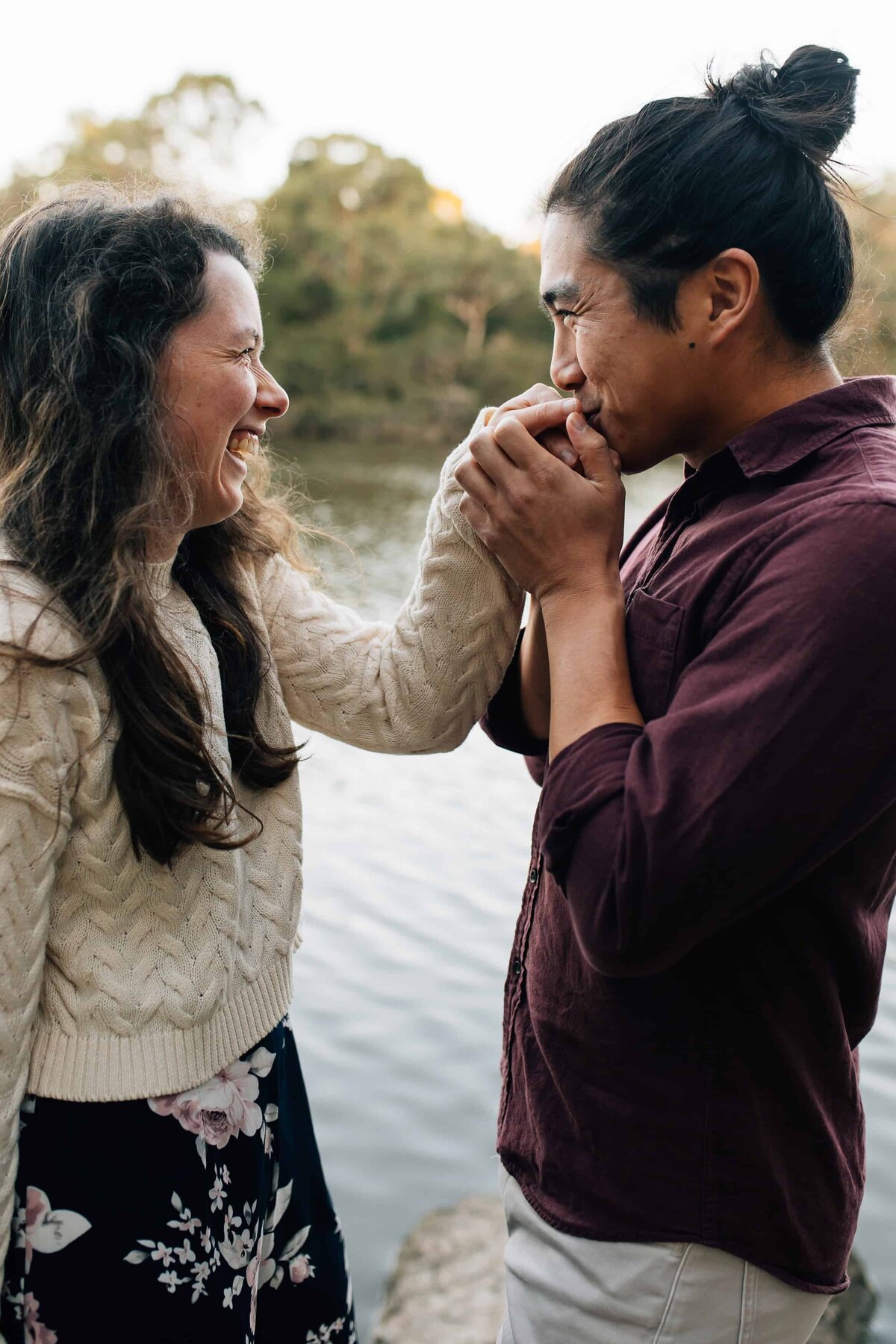 Man holding and kissing hand of fiancée after proposing during a couples photoshoot Melbourne, And So I Don't Forget Photography 