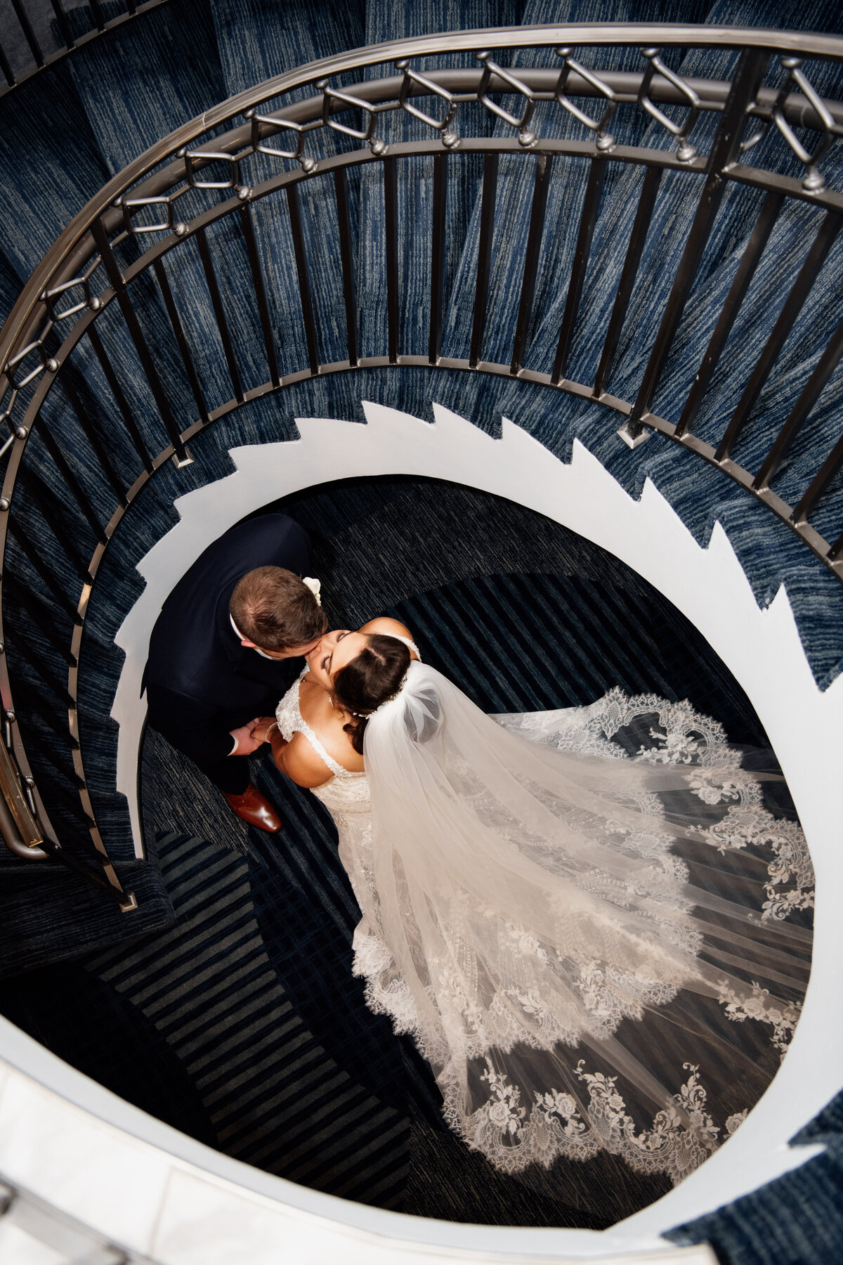 bride and groom kissing on staircase