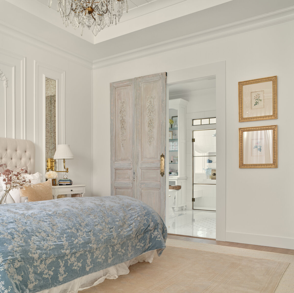 luxury bedroom with white dresser white sitting chiar and bed with blue blanket