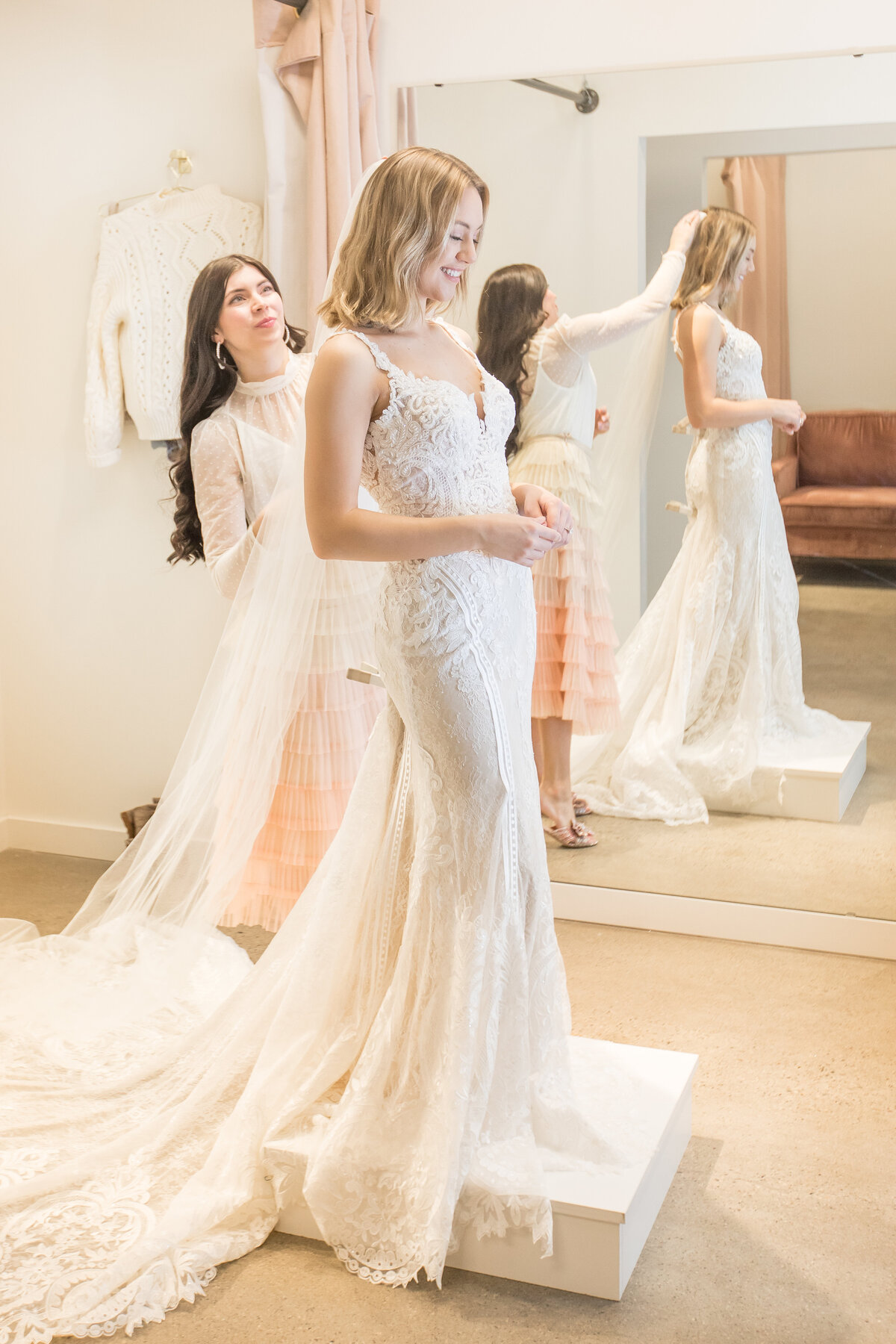 a woman trying on a wedding dress in a boutique