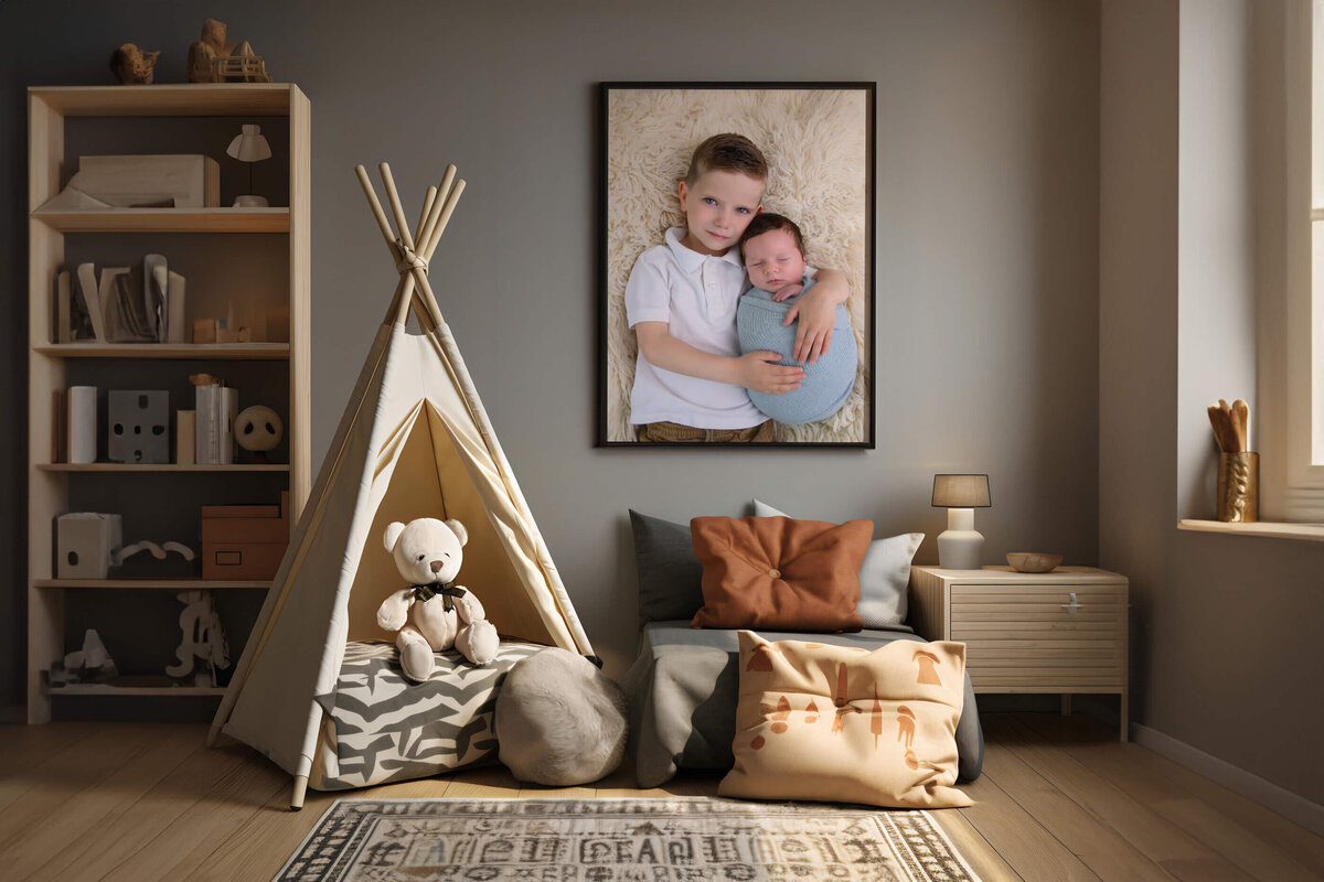 playroom with a framed photo of a big brother holding his little brother who is wrapped in blue for their family newborn photography session in Burlington, On