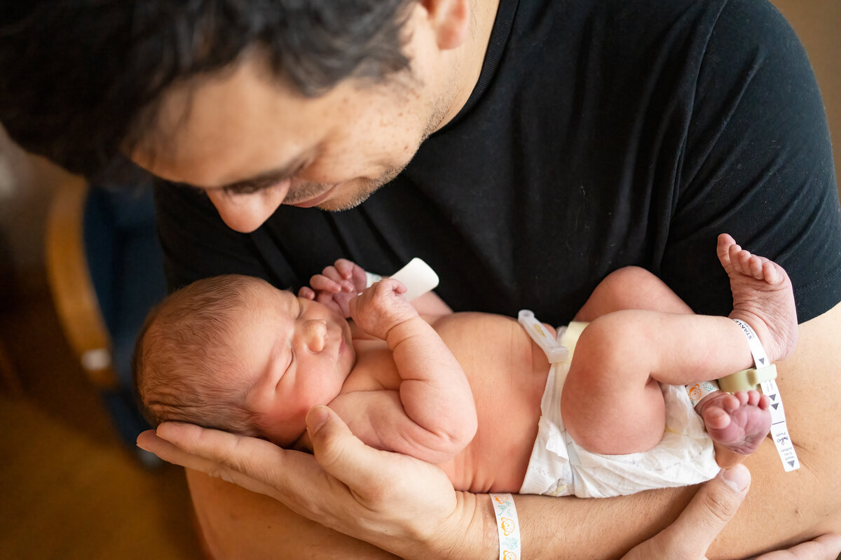 Dad cradling baby in arms